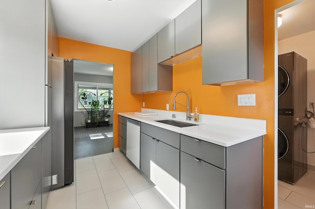 1914 Emerson Ave, Fort Wayne, IN 46808 - kitchen featuring gray cabinetry, freestanding refrigerator, estacked washer and dryer, dishwashing machine, and light countertops