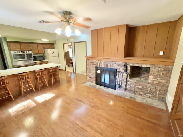 3105 Perrysburg Rd, Logansport, IN 46947 - living room featuring a ceiling fan, light wood finished floors, and a brick fireplace