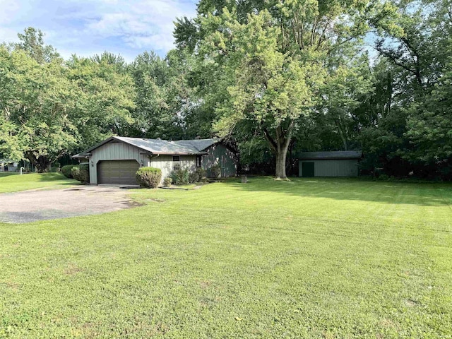 3105 Perrysburg Rd, Logansport, IN 46947 - view of grassy yard with a garage and asphalt driveway