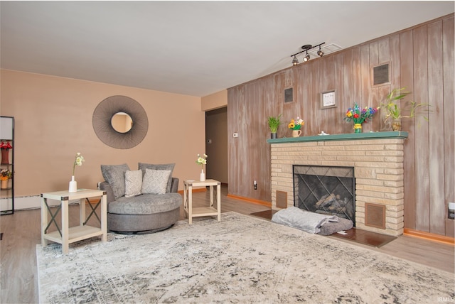 1401 S M St, Elwood, IN 46036 - living room featuring wood finished floors, a fireplace, and wooden walls