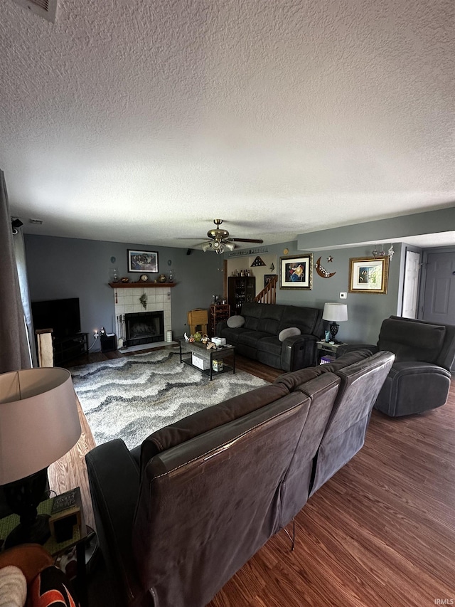 619 Briarfield Dr, Fort Wayne, IN 46825 - living room with a textured ceiling, wood finished floors, a ceiling fan, and a tile fireplace