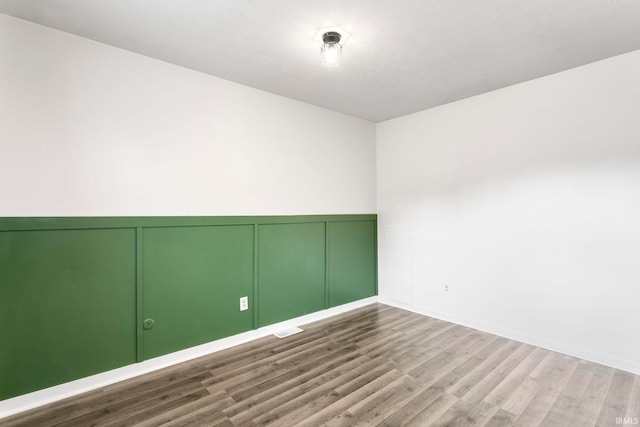 51278 Arch St, Granger, IN 46530 - unfurnished room with wood finished floors, a decorative wall, and wainscoting