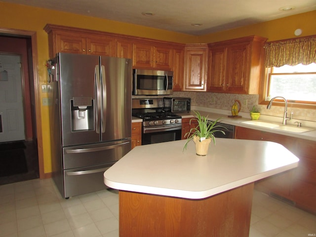 4109 E Woodland Ct, Leesburg, IN 46538 - kitchen featuring stainless steel appliances, light countertops, brown cabinetry, backsplash, and a kitchen island