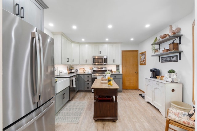 3139 E Colony Ave, Columbia City, IN 46725 - kitchen with appliances with stainless steel finishes, open shelves, gray cabinets, light wood finished floors, and tasteful backsplash