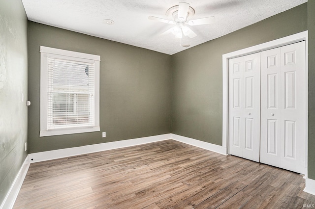 240 Bank St, Elkhart, IN 46516 - unfurnished bedroom with wood finished floors, a closet, and a ceiling fan