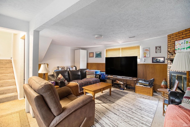 3301 Cabot Dr, South Bend, IN 46635 - carpeted living area featuring stairs, wood walls, wainscoting, a brick fireplace, and a textured ceiling