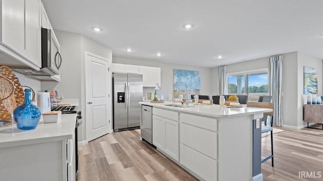 1185 Catesby Ct, Fort Wayne, IN 46818 - kitchen featuring appliances with stainless steel finishes, light wood finished floors, a kitchen bar, white cabinetry, and recessed lighting