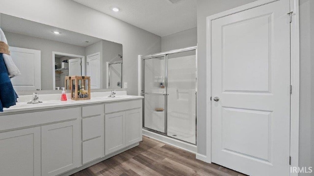 1185 Catesby Ct, Fort Wayne, IN 46818 - bathroom with a shower stall, wood finished floors, double vanity, and recessed lighting