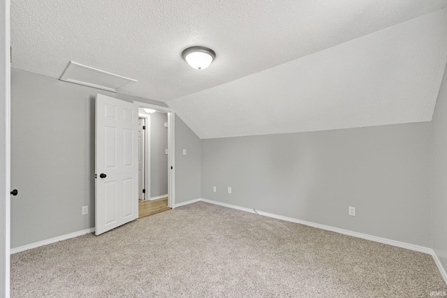2725 Fox Ave, Fort Wayne, IN 46807 - additional living space with light colored carpet, attic access, a textured ceiling, and vaulted ceiling