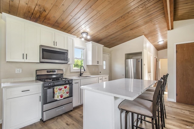 56435 Eastlea Dr, South Bend, IN 46619 - kitchen with appliances with stainless steel finishes, vaulted ceiling, wooden ceiling, a kitchen island, and a breakfast bar