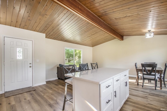 56435 Eastlea Dr, South Bend, IN 46619 - kitchen with a breakfast bar, white cabinetry, a center island, light wood finished floors, and wooden ceiling