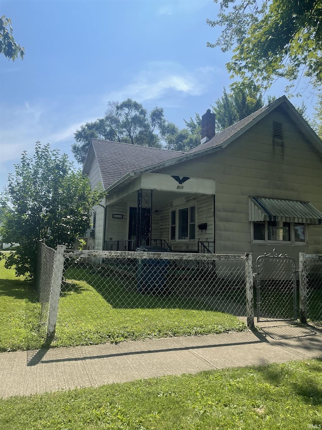 517 S Main St, Jonesboro, IN 46938 - rear view of property featuring a fenced front yard, a chimney, a shingled roof, a gate, and a porch