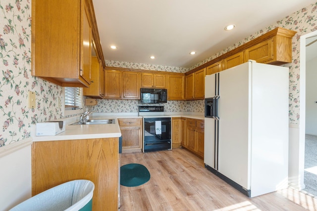 1408 Duesenberg Dr, Auburn, IN 46706 - kitchen featuring black appliances, wallpapered walls, light wood-type flooring, brown cabinetry, and light countertops