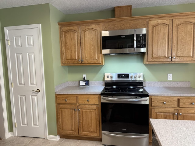 9825 Tamar Trl, Fort Wayne, IN 46825 - kitchen featuring stainless steel appliances, light countertops, and brown cabinets
