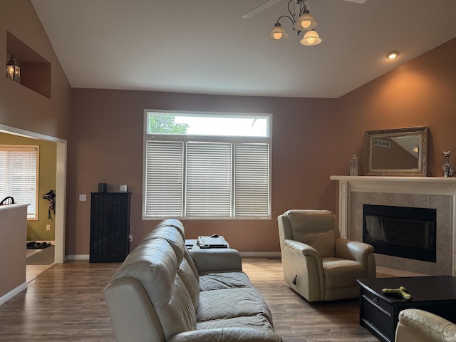 9825 Tamar Trl, Fort Wayne, IN 46825 - living area featuring light wood-style flooring, a tiled fireplace, and vaulted ceiling