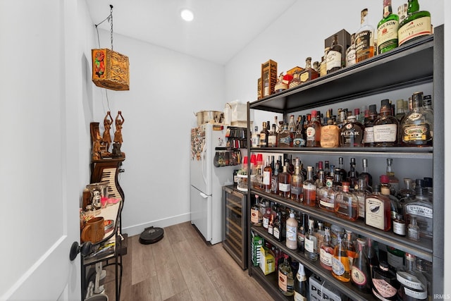 1229 Corby Blvd, South Bend, IN 46617 - indoor dry bar featuring wood finished floors, beverage cooler, freestanding refrigerator, and recessed lighting