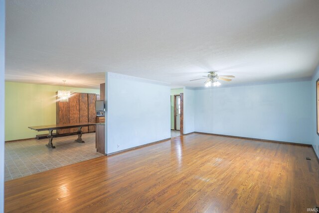 348 Arthur Rd, Springville, IN 47462 - unfurnished room with wood finished floors, ceiling fan, and a chandelier