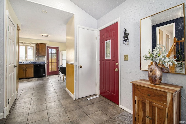 19545 Hildebrand St, South Bend, IN 46614 - entrance foyer featuring a textured wall, lofted ceiling, and a textured ceiling