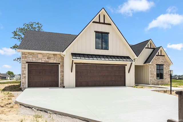17882 Pavia Pass, Huntertown, IN 46748 - view of front facade with board and batten siding, stone siding, concrete driveway, a standing seam roof, and roof with shingles