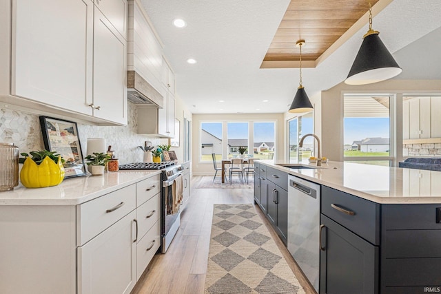 17882 Pavia Pass, Huntertown, IN 46748 - kitchen with stainless steel appliances, white cabinetry, a center island with sink, backsplash, and light wood-type flooring