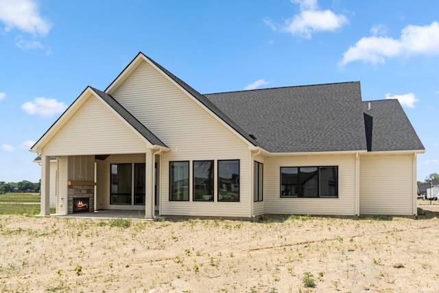 17882 Pavia Pass, Huntertown, IN 46748 - back of house featuring a patio area, a large fireplace, and roof with shingles