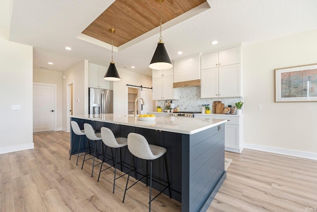 17882 Pavia Pass, Huntertown, IN 46748 - kitchen featuring stainless steel refrigerator with ice dispenser, premium range hood, tasteful backsplash, light wood-style flooring, and white cabinetry