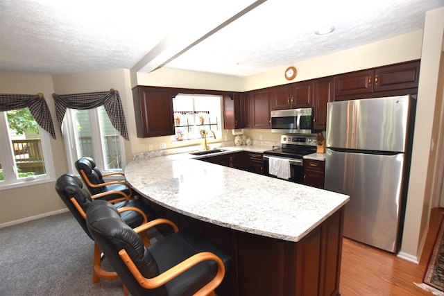 9841 S Harbour Pointe Dr, Bloomington, IN 47401 - kitchen with appliances with stainless steel finishes, a peninsula, a textured ceiling, and a breakfast bar area