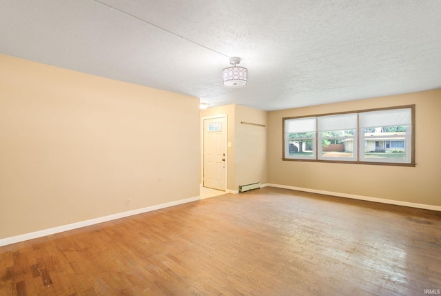 23099 Gardena Pl, Elkhart, IN 46514 - spare room with light wood-type flooring, baseboard heating, and a textured ceiling
