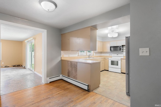 23099 Gardena Pl, Elkhart, IN 46514 - kitchen with electric range, stainless steel microwave, a peninsula, light countertops, and tasteful backsplash