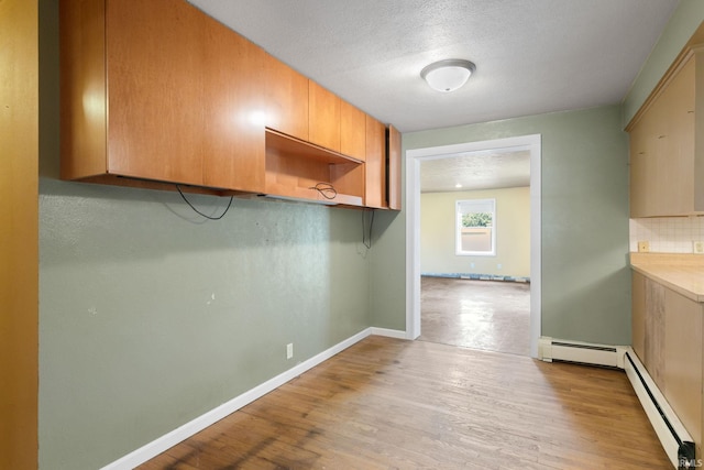 23099 Gardena Pl, Elkhart, IN 46514 - kitchen with a baseboard radiator, light wood-type flooring, and backsplash