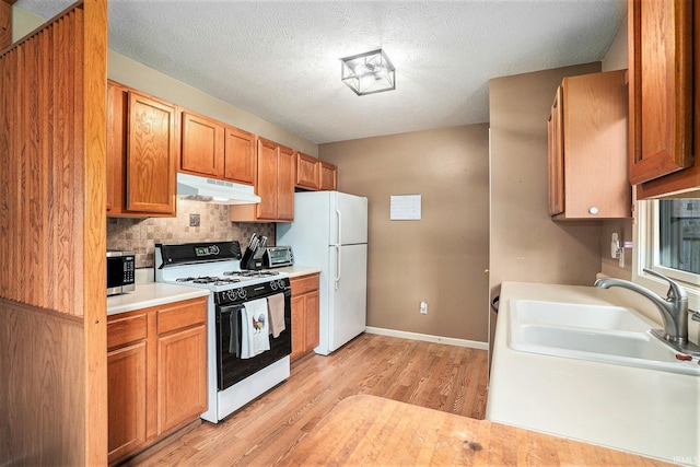 23200 S Oakleaf Dr, Elkhart, IN 46514 - kitchen featuring range with electric cooktop, under cabinet range hood, stainless steel microwave, light wood-style floors, and freestanding refrigerator