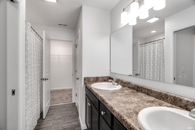 197 Folkston Way, Lafayette, IN 47905 - bathroom featuring double vanity, wood finished floors, and a walk in closet