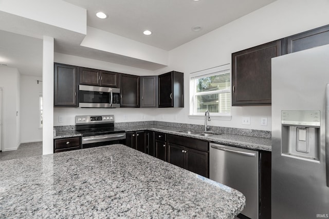 197 Folkston Way, Lafayette, IN 47905 - kitchen featuring appliances with stainless steel finishes, light stone counters, dark brown cabinets, and recessed lighting