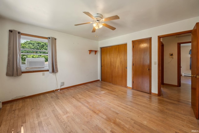 303 N Center St, Boswell, IN 47921 - unfurnished bedroom featuring two closets, a baseboard radiator, light wood finished floors, cooling unit, and a ceiling fan