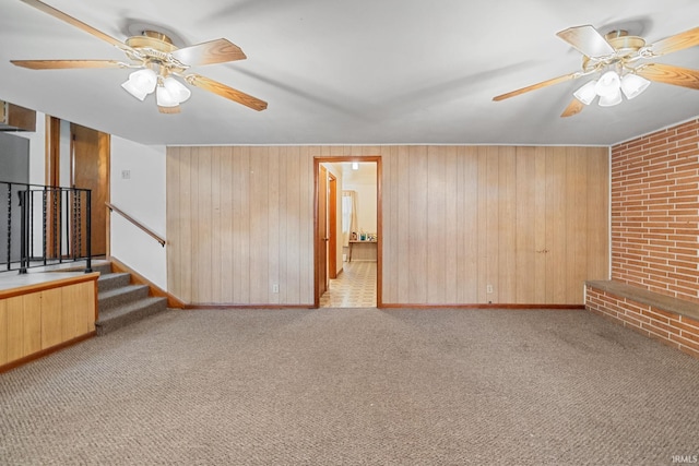303 N Center St, Boswell, IN 47921 - spare room with ceiling fan, stairway, carpet, wood walls, and brick wall