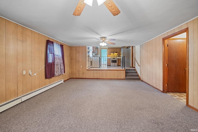 303 N Center St, Boswell, IN 47921 - unfurnished living room featuring a ceiling fan, baseboard heating, wood walls, carpet, and stairs