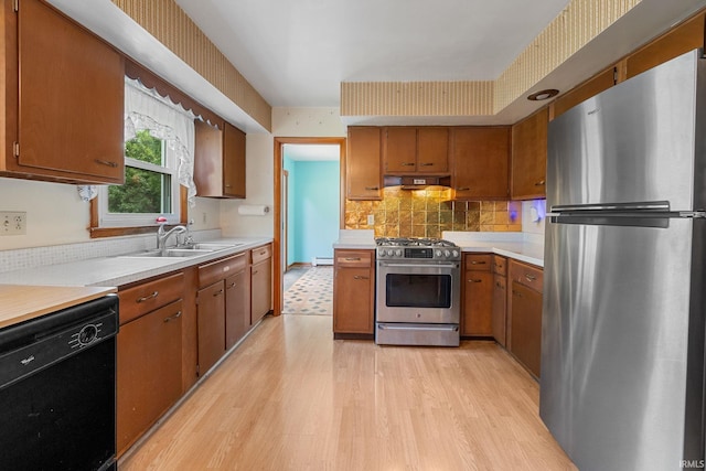 303 N Center St, Boswell, IN 47921 - kitchen with appliances with stainless steel finishes, under cabinet range hood, light countertops, and brown cabinetry