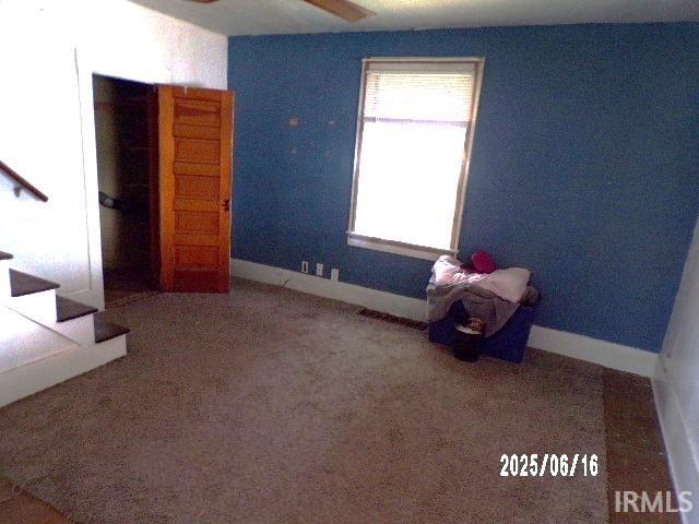 2401 S Selby St, Marion, IN 46953 - unfurnished room featuring stairs, a ceiling fan, and carpet floors