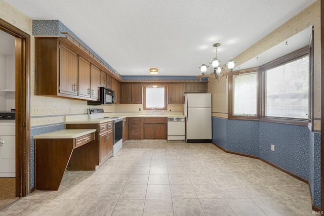5610 E State Blvd, Fort Wayne, IN 46815 - kitchen featuring white appliances, wallpapered walls, light countertops, a chandelier, and washer / clothes dryer