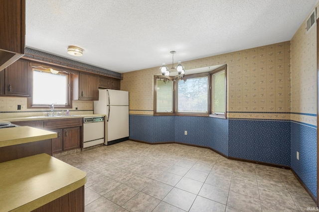 5610 E State Blvd, Fort Wayne, IN 46815 - kitchen with white appliances, wallpapered walls, a textured ceiling, a chandelier, and light countertops