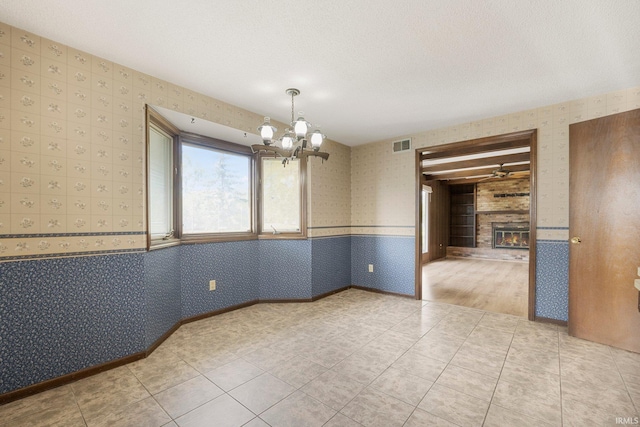 5610 E State Blvd, Fort Wayne, IN 46815 - unfurnished dining area with wallpapered walls, a chandelier, a large fireplace, and light tile patterned floors