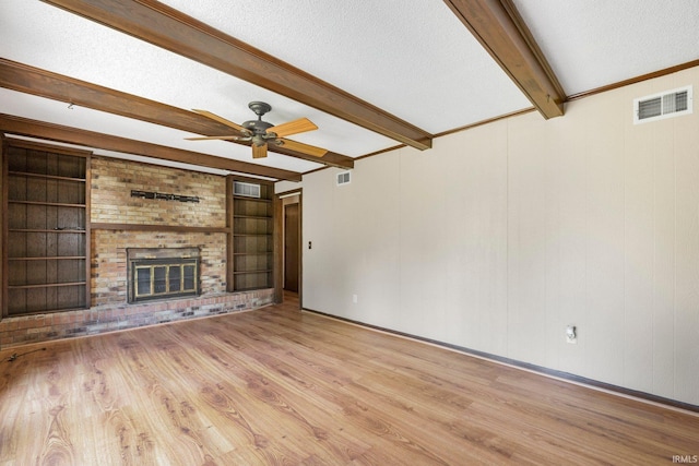 5610 E State Blvd, Fort Wayne, IN 46815 - unfurnished living room featuring beam ceiling, a textured ceiling, wood finished floors, a ceiling fan, and a fireplace