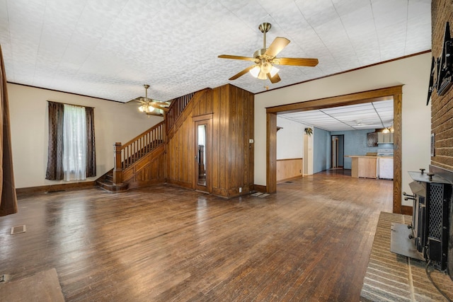 408 E Main St, Butler, IN 46721 - unfurnished living room with stairs, wood finished floors, wooden walls, and ceiling fan