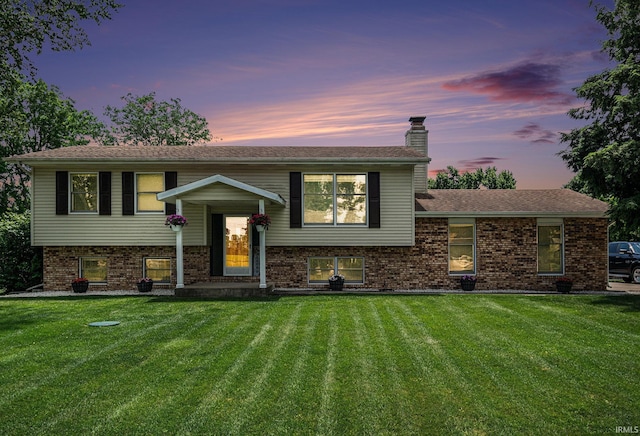 26946 Heather Ln, Elkhart, IN 46514 - view of front of house with a front lawn, a chimney, and brick siding