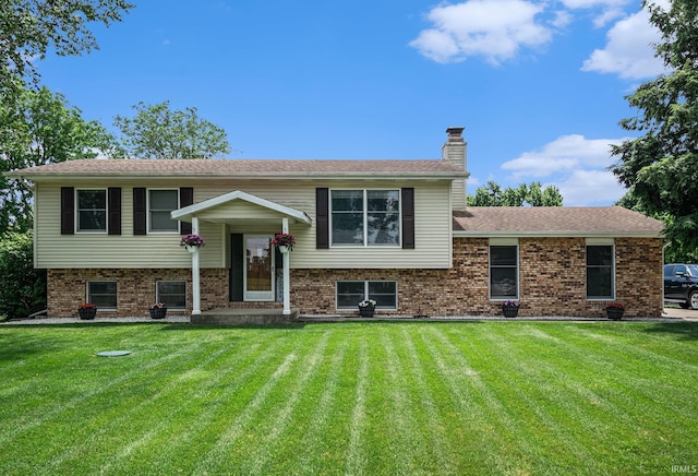 26946 Heather Ln, Elkhart, IN 46514 - view of front of house with a front yard, a chimney, and brick siding