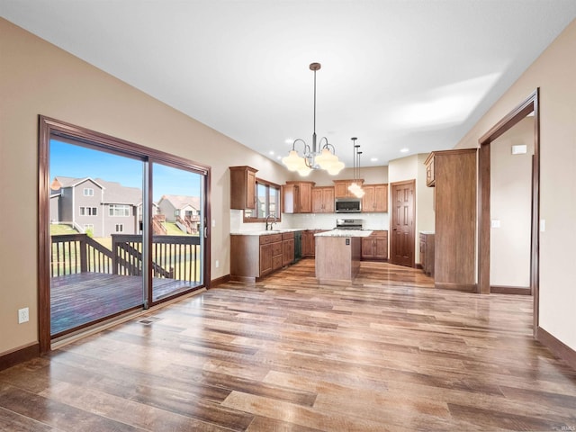 188 Begonia Ct, Fort Wayne, IN 46814 - kitchen featuring wood finished floors, a chandelier, light countertops, a center island, and brown cabinets