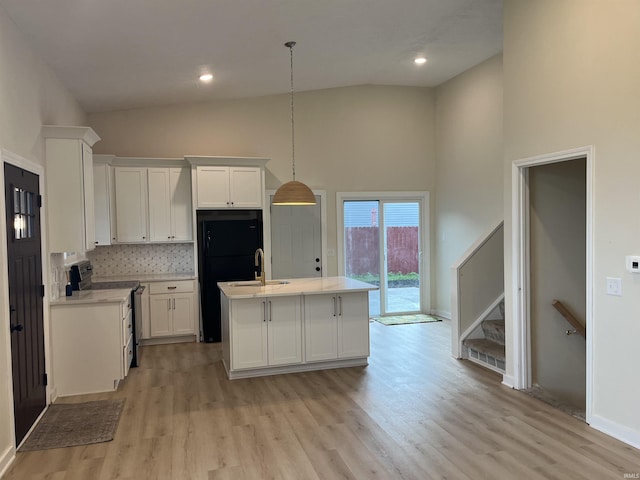 732 Conner Dr, Mishawaka, IN 46544 - kitchen with electric range, high vaulted ceiling, light countertops, white cabinets, and light wood-style floors