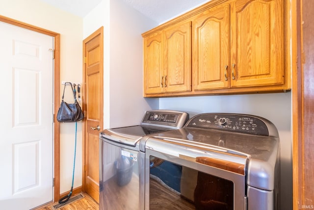 114 Whispering Ln, South Whitley, IN 46787 - washroom with washer and dryer, cabinet space, and light wood finished floors