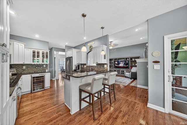 51733 Copperfield Rdg, Granger, IN 46530 - kitchen featuring beverage cooler, backsplash, dark countertops, a breakfast bar area, and a peninsula