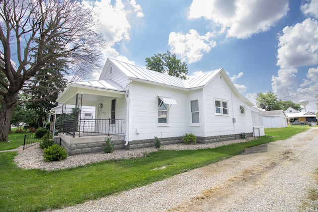 827 W Elm St, Union City, IN 47390 - view of home's exterior with covered porch, a standing seam roof, a metal roof, and a lawn